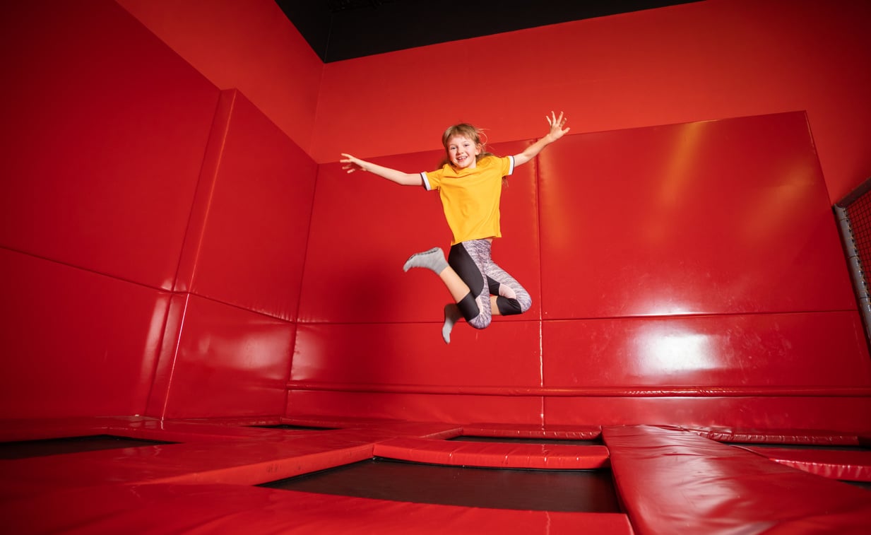 Little girl jumping on trampoline in fly park