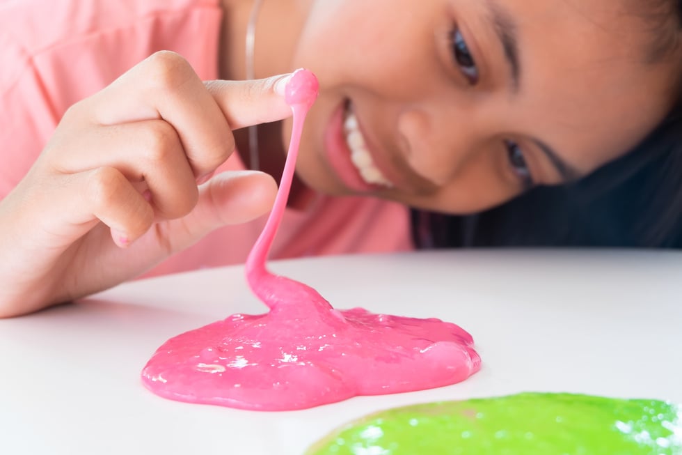 Hand Holding Homemade Toy Called Slime, Kids having fun and being creative by science experiment.